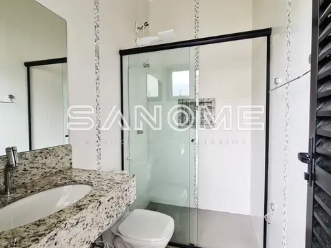 Banheiro com bancada em granito e box vidrado