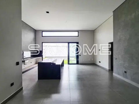 Sala e cozinha integradas com piso cinzento e janelas amplas