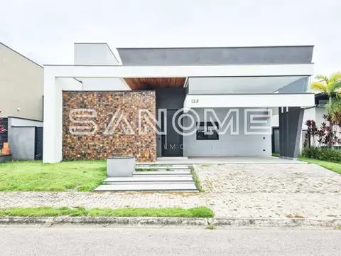 Fachada de casa moderna com garagem e painel de tijolos