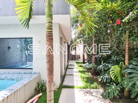 Corredor com piscina e vegetação tropical