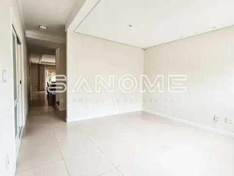 Sala vazia com piso de cerâmica e corredor ao fundo
