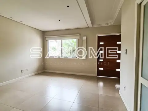 Sala com piso cerâmico e porta de entrada em madeira