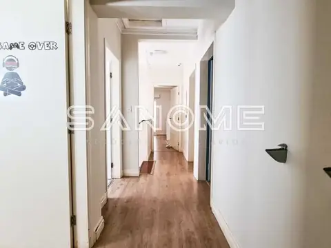 Corredor com portas brancas e piso de madeira