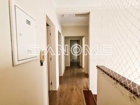 Corredor com portas de acesso e piso de madeira