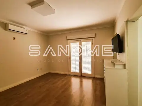 Sala ampla com piso de madeira e portas de vidro