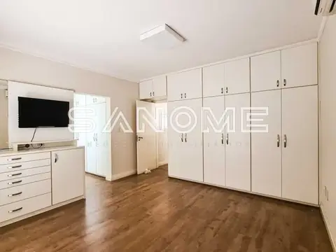Closet com armários brancos e piso em madeira