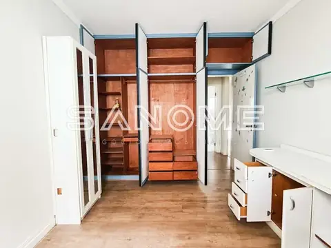 Closet amplo com guarda-roupa embutido e portas abertas