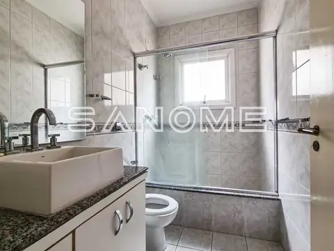 Banheiro com pia, vaso sanitário e box com vidro