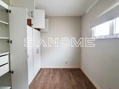 Cozinha com armários brancos e piso de madeira