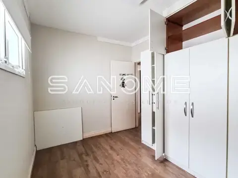 Quarto com guarda-roupa branco e piso de madeira