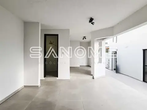 Sala ampla com piso em porcelanato e porta de vidro fumê