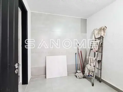 Cômodo em reforma com porta e materiais de construção