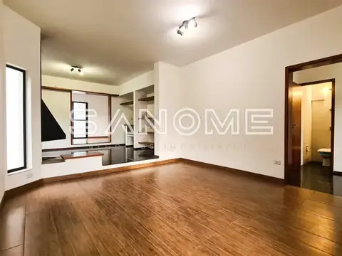 Sala de estar com piso de madeira e cozinha integrada