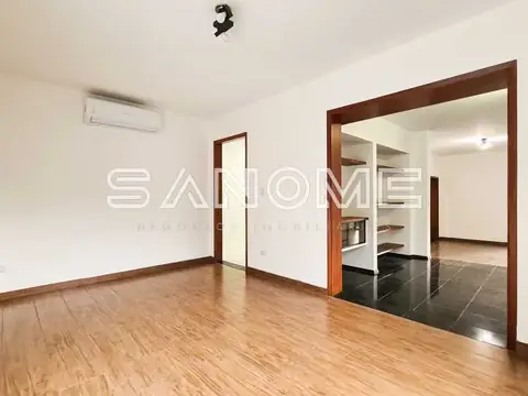 Sala ampla com piso de madeira e espelho grande