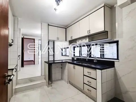 Cozinha planejada com bancada preta e armários brancos