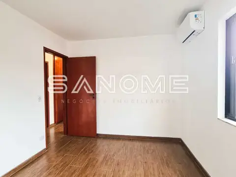 Quarto com porta de madeira e piso em laminado