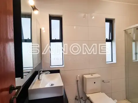 Banheiro com pia, vaso sanitário e box de vidro