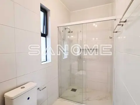 Banheiro com chuveiro blindex e sanitário branco