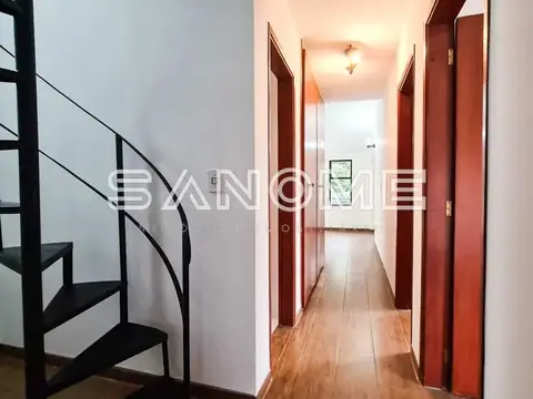 Corredor interno com portas vermelhas e escada