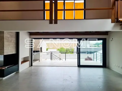 Sala integrada com piso de concreto e varanda