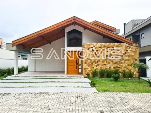 Fachada de casa com garagem e revestimento em pedra