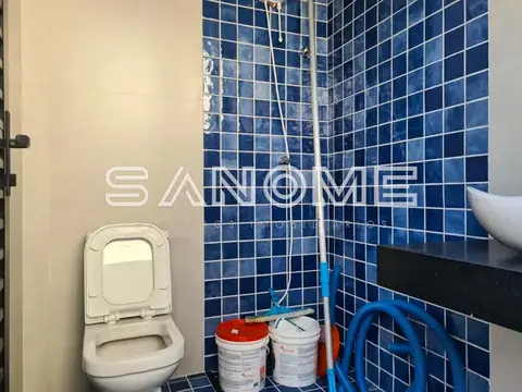 Banheiro com azulejos azuis e vaso sanitário branco