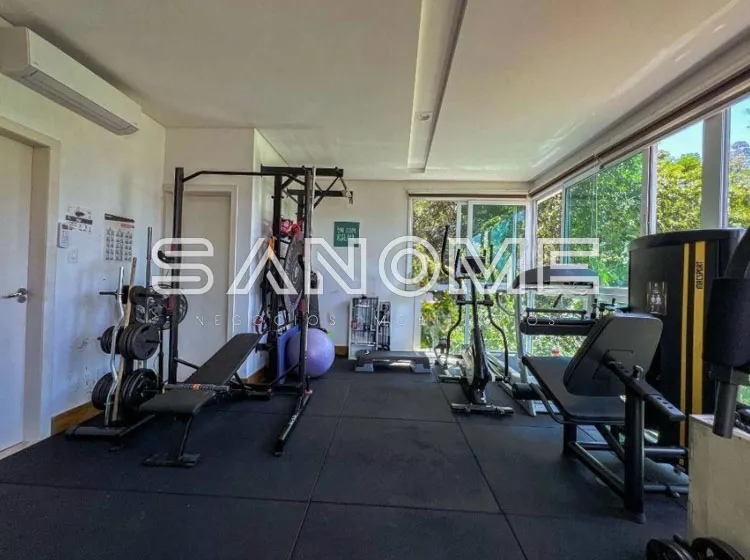 Sala de ginástica com equipamentos e janelas