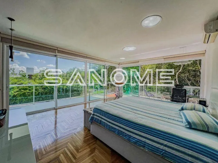 Quarto com cama de casal e varanda com vista para vegetação