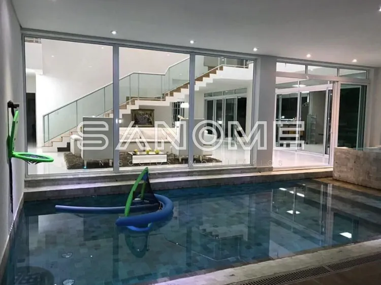 Piscina interna com vista para sala e escada