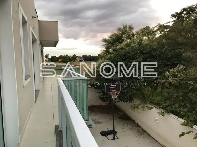 Terraço com vista para área arborizada e céu nublado