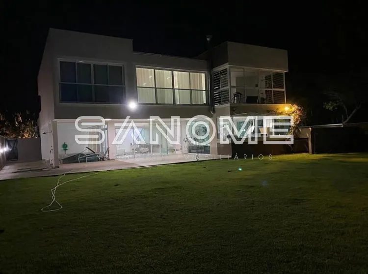 Casa moderna de dois andares com fachada branca à noite