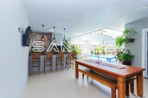 Sala integrada com mesa de madeira e bancada de cozinha