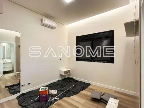 Sala de estar com painel de TV e piso de madeira