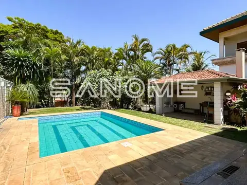 Área externa com piscina e casa ao fundo