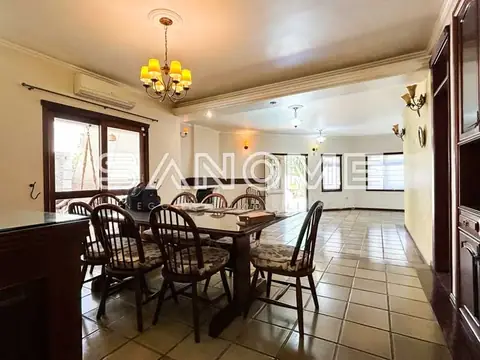Sala de jantar com mesa de madeira e cadeiras estofadas