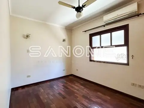 Quarto com piso de madeira e janela ampla