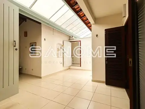 Corredor interno com piso de cerâmica e claraboias