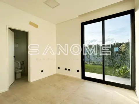 Sala com piso em cerâmica e porta de vidro com vista para jardim