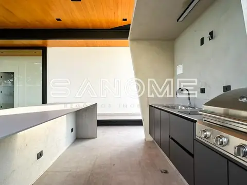 Cozinha com bancada branca e cooktop inox
