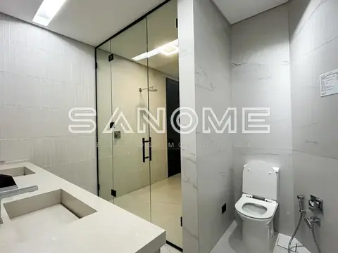 Banheiro com chuveiro em box e bancada com pia