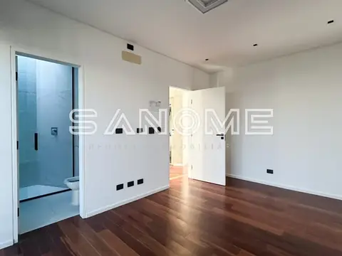 Suíte com banheiro e piso de madeira
