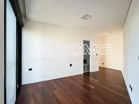 Sala vazia com piso de madeira e paredes brancas