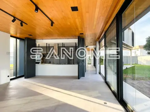 Sala integrada com cozinha e grandes janelas de vidro