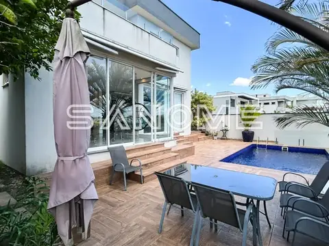 Área externa com piscina e mesa de refeições