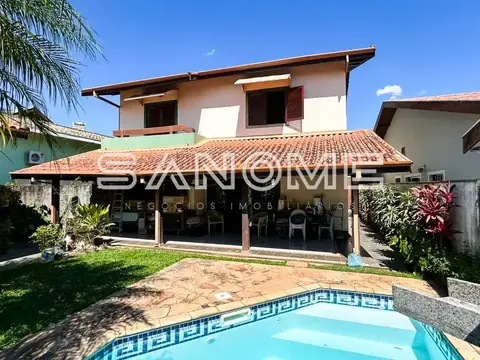 Casa de dois pavimentos com piscina e área coberta