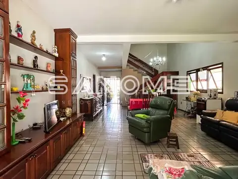 Sala de estar com sofá verde e painel de madeira