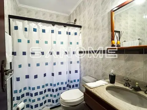 Banheiro com cortina de chuveiro azul e branca
