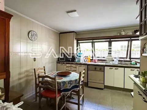 Cozinha com mesa de refeições e vista para janelas