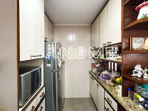 Cozinha planejada com geladeira e bancada em granito