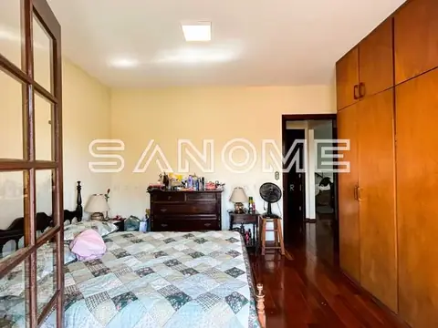 Quarto com cama de casal e guarda-roupa em madeira